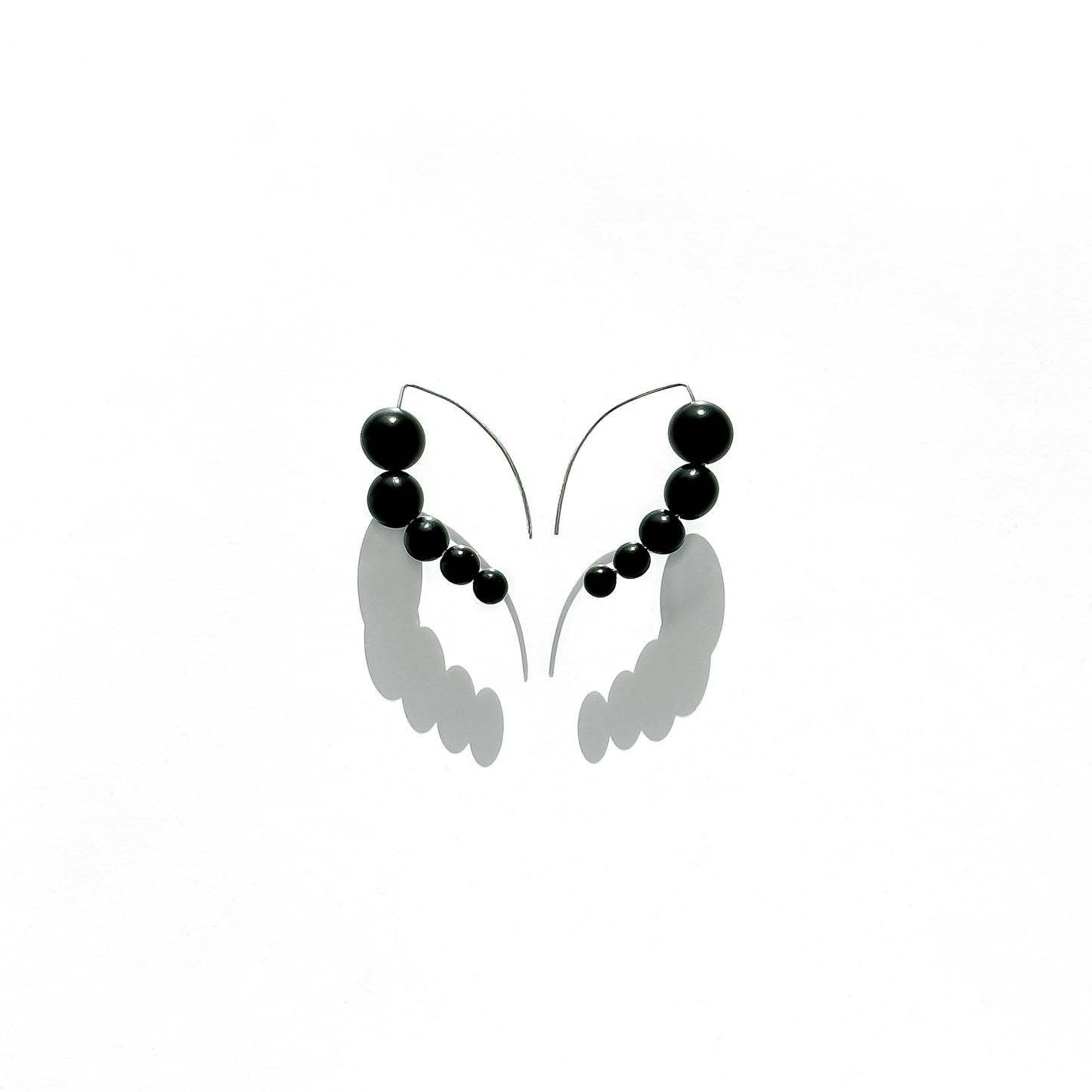 Harmony 5 earrings made of tagua nut spheres threaded into a handmade sterling silver earring hoop