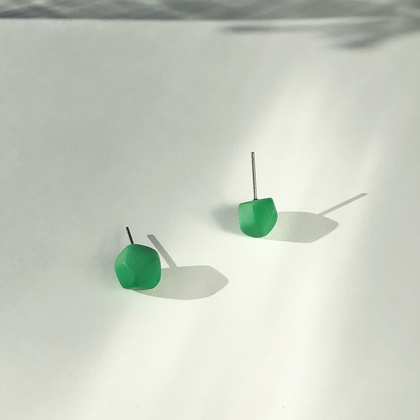 Asymmetric stud earrings with faceted sides
