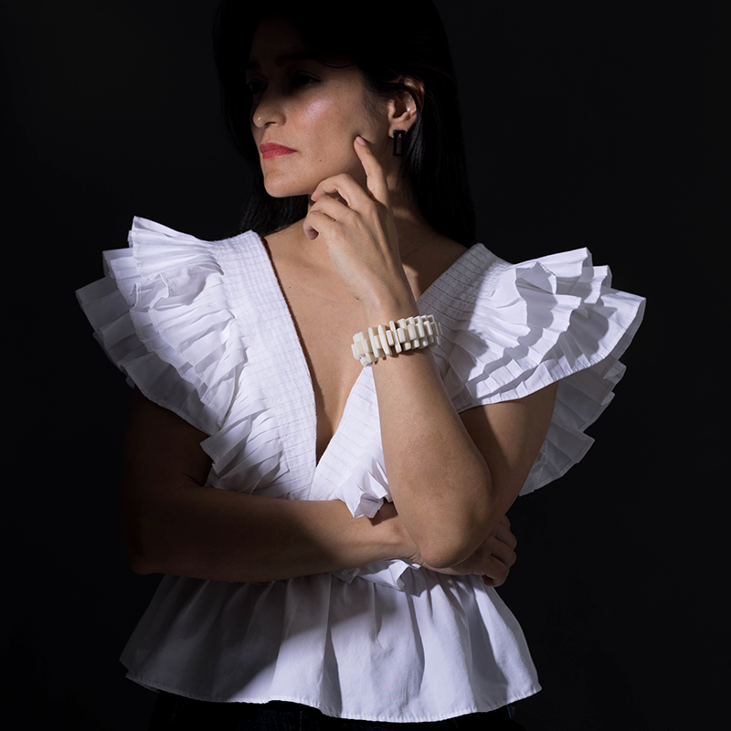 Modell wearing a white, architectonic bracelet made with tagua nuts