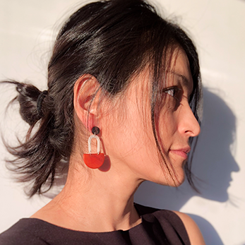 Model wearing colourful dangling earrings handmade with sustainable Tagua Nut