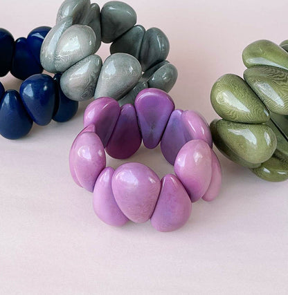 Beaded stretch bracelets with glossy, rounded pebble-like tagua nut beads. 