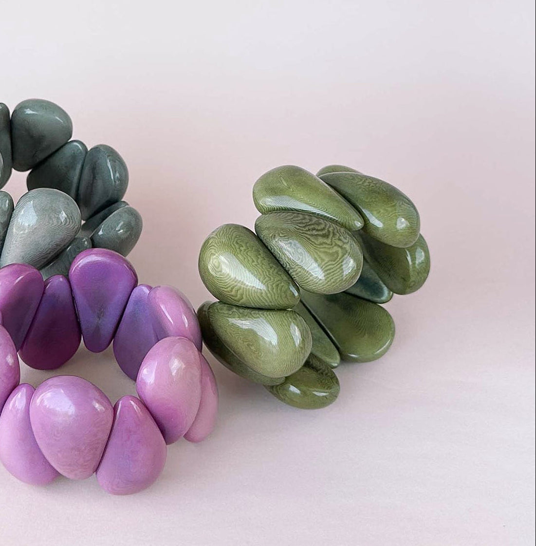Beaded stretch bracelets with glossy, rounded pebble-like tagua nut beads.