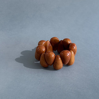 Brown beaded tagua nut bracelet on a light blue background