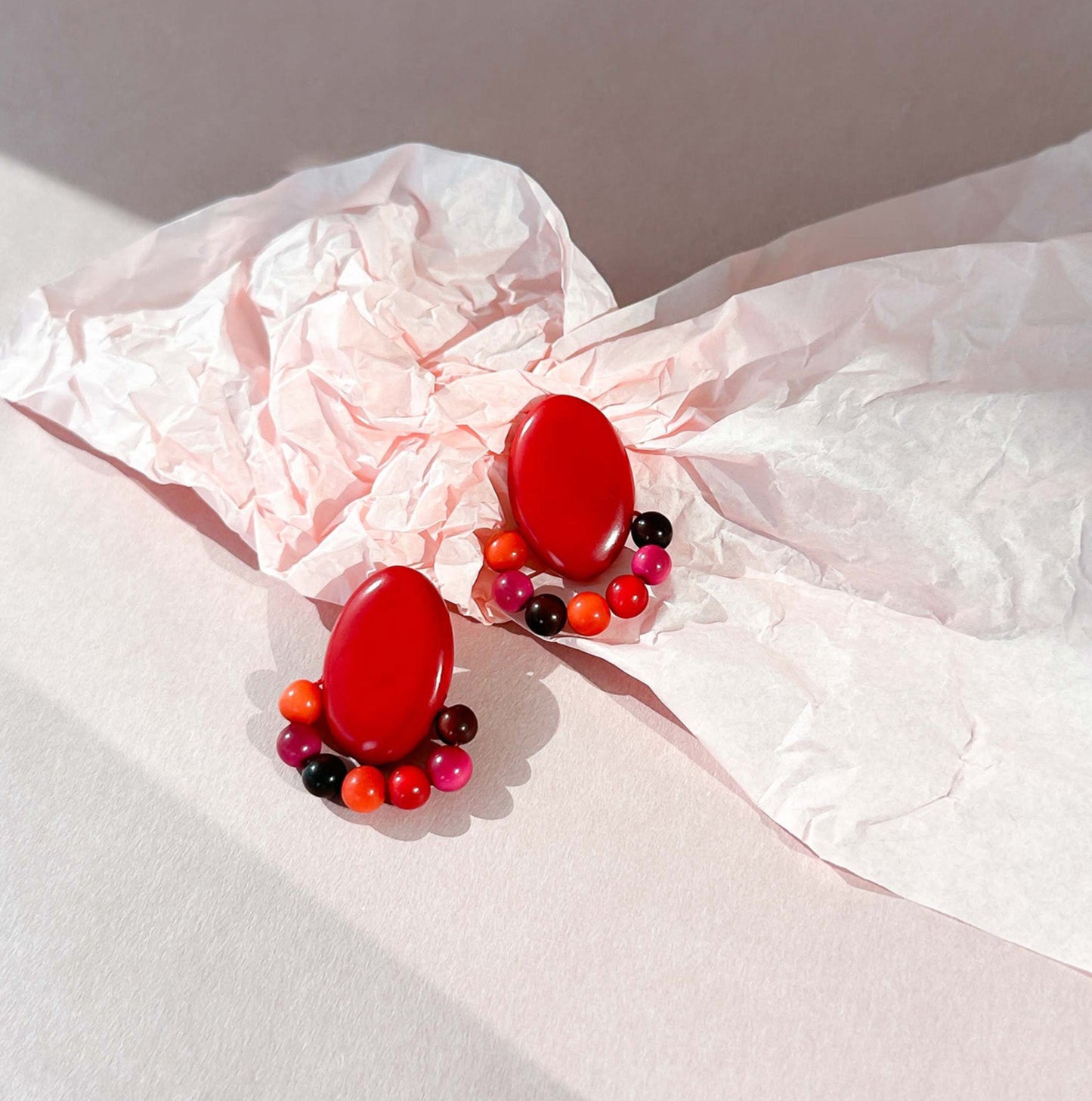 Red earrings handmade with tagua nut beads and natural dyes.
