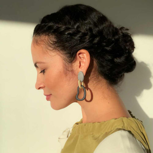 model wearing long, dangling Maite earrings, handmade with tags nuts